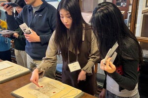 Shinbi Lee shows a visitor handwritten letters from prominent economists that were on display.