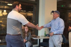 Morris Kleiner shakes hands with a presenter as he accepts his lifetime achievement award.