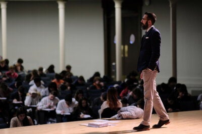 DiIanni lectures to hundreds of students from the stage of Foellinger Auditorium.
