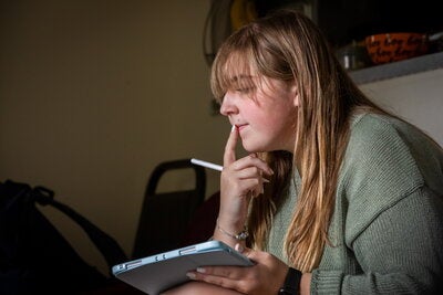 A student focuses on her notes while studying for a course.