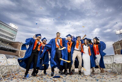 Confetti rains on a group of students as they celebrate graduation at Gies Memorial Stadium.