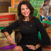 Karen Layng National Girl Scouts President sits in front of cookie boxes 